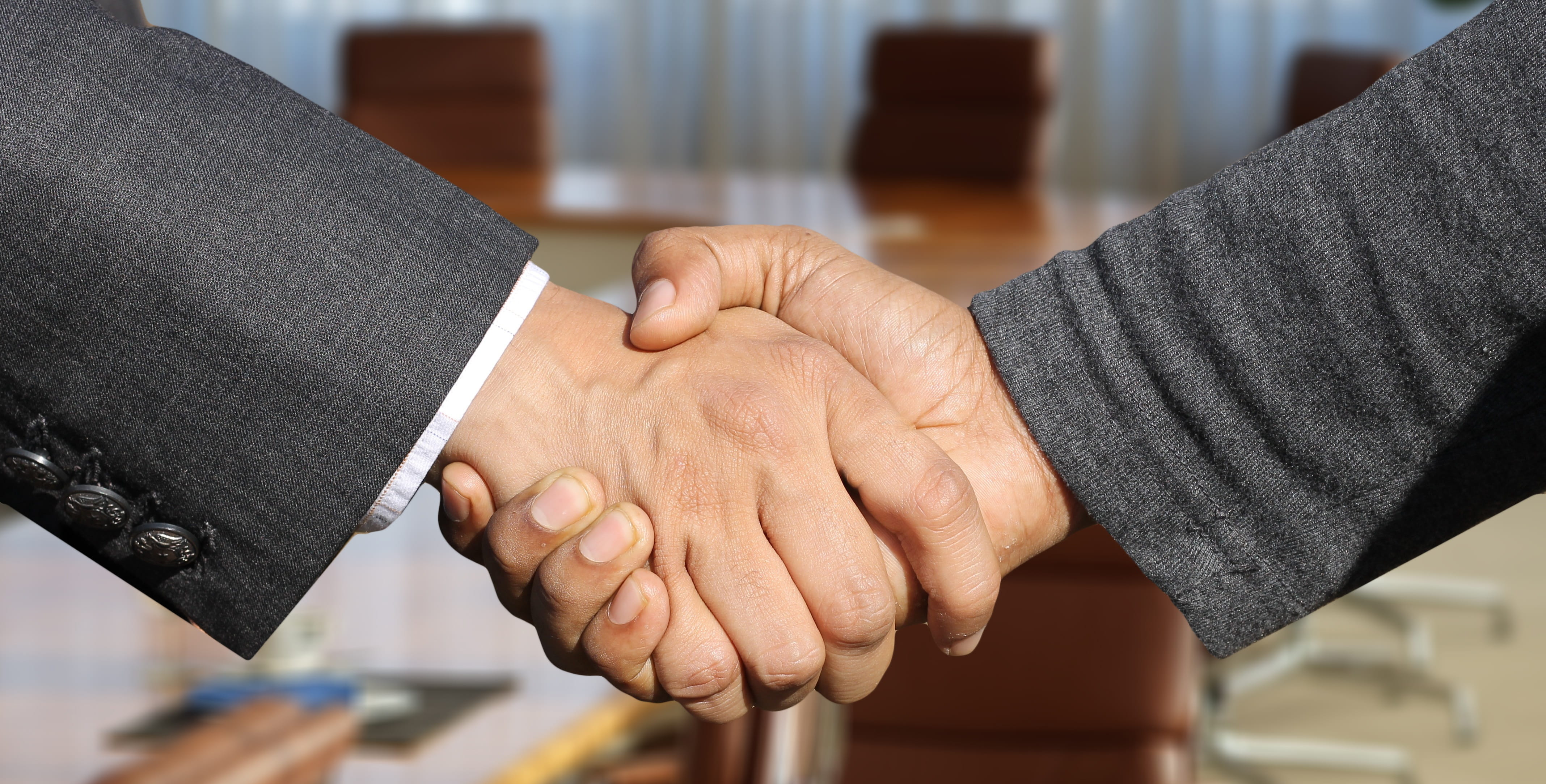 Two men shaking hands, representing negotiating a fair settlement with an insurance company 