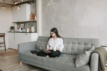 Woman on couch using laptop