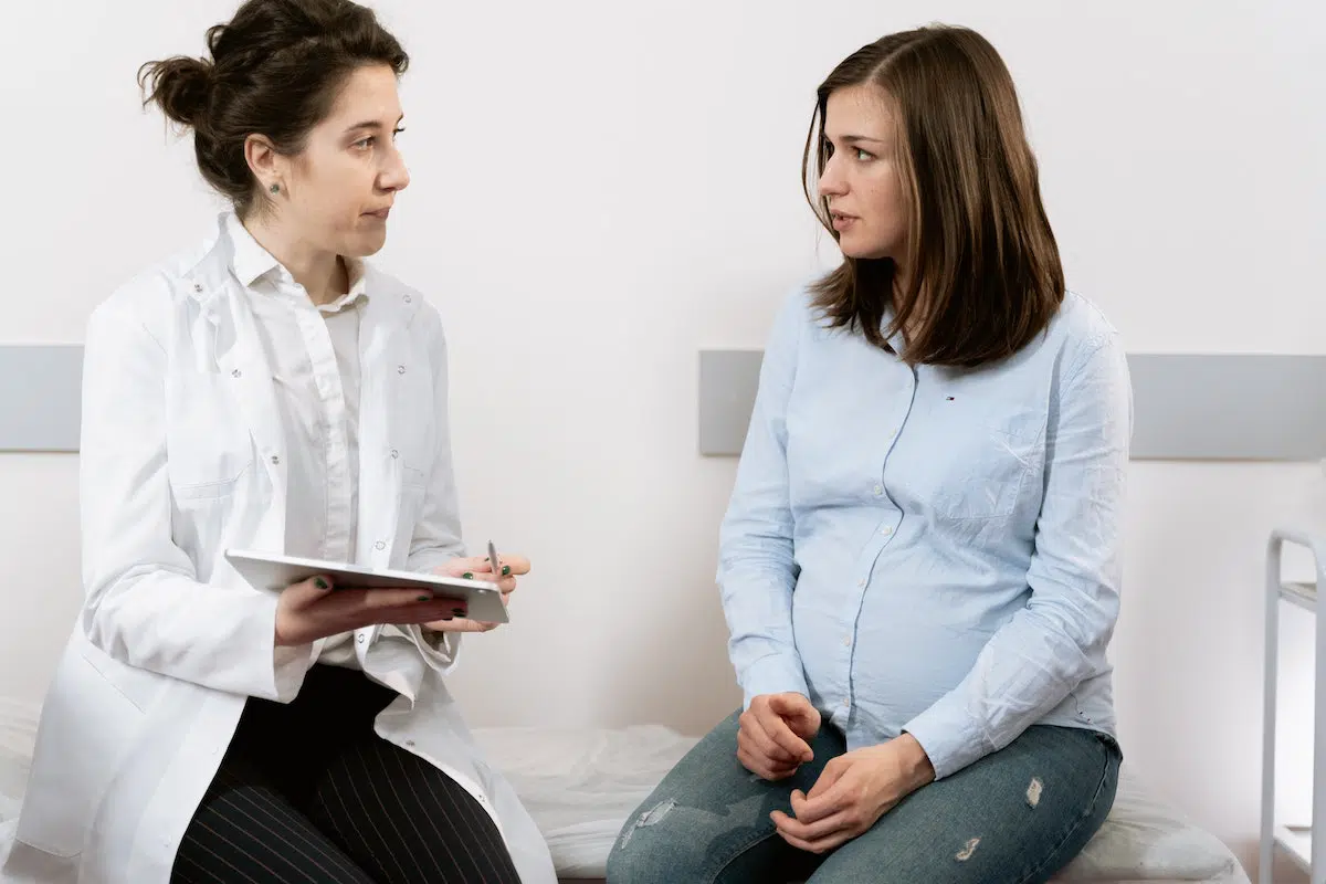 Pregnant woman talking to her doctor after a slip and fall accident