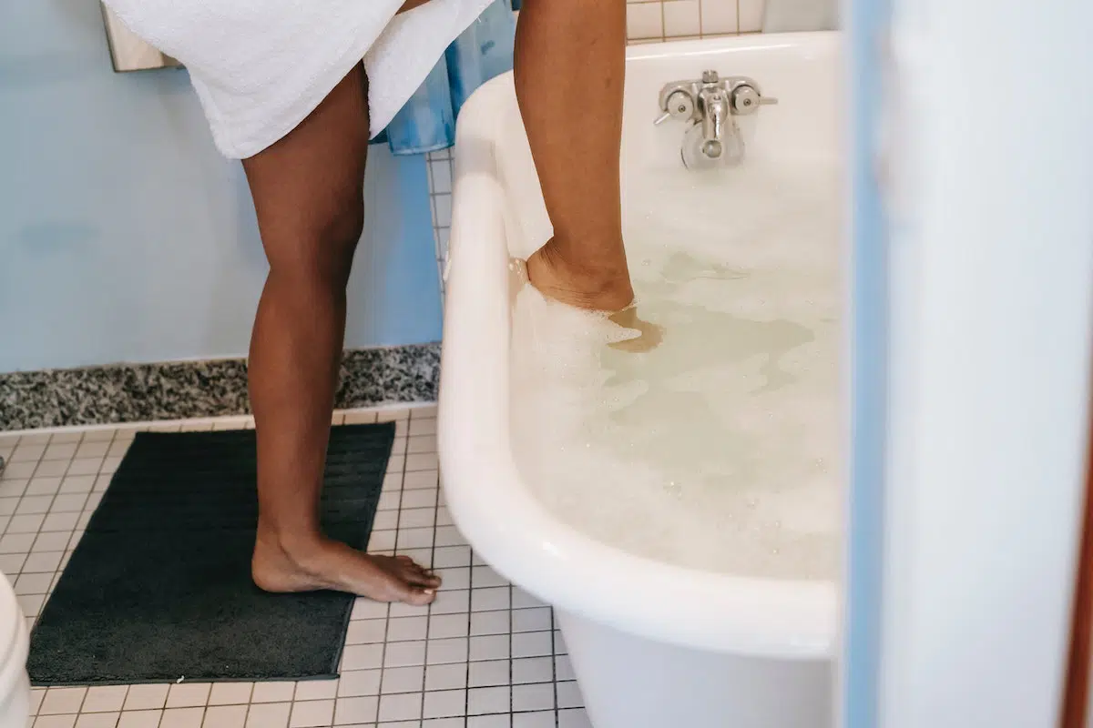 Woman stepping into bathtub