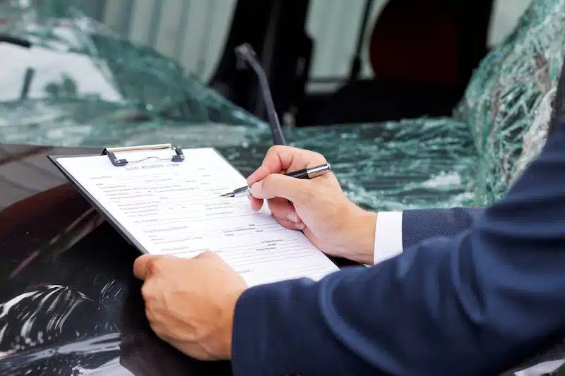 Person In A Suit Filing Out Car Crash Documents