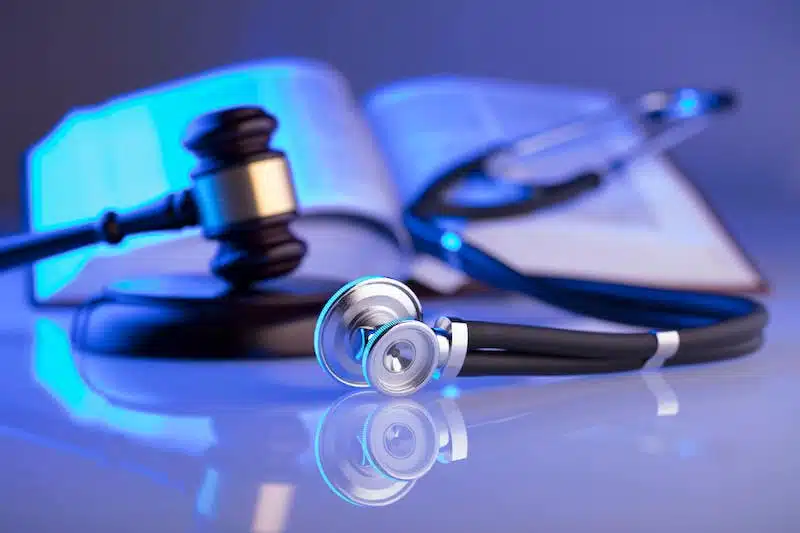 Law Hammer And A Stethoscope Laying On A Table