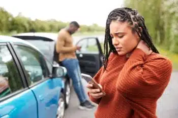 Woman makes a call to emergency services after a car accident.