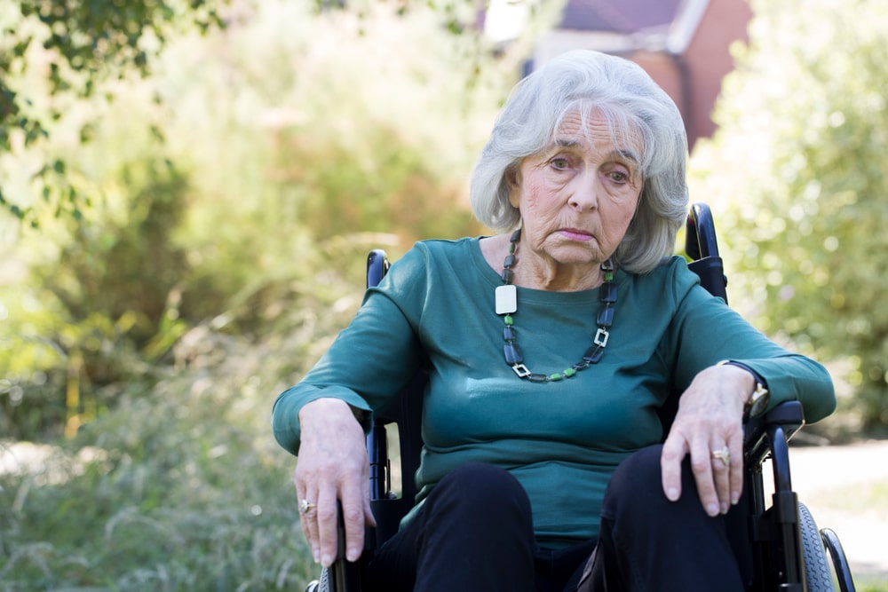 Visibly Upset Elderly Woman In A Wheelchair