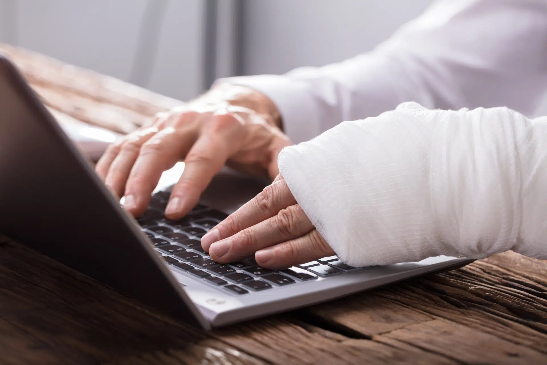 Injured man in cast working on laptop